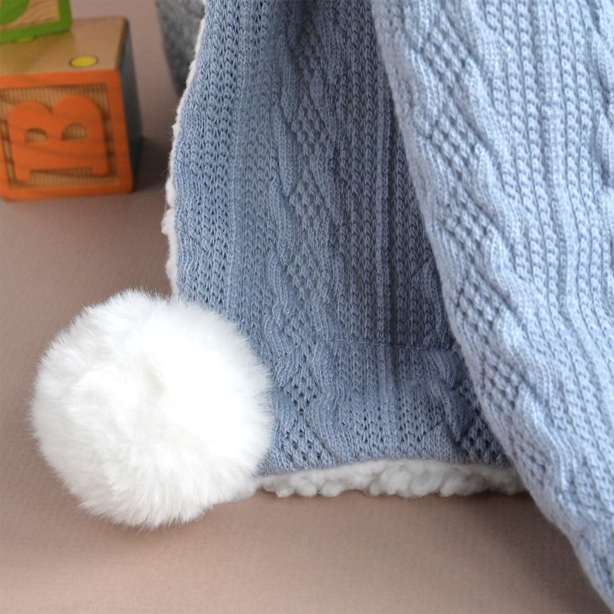 baby knitted blanket with pom poms