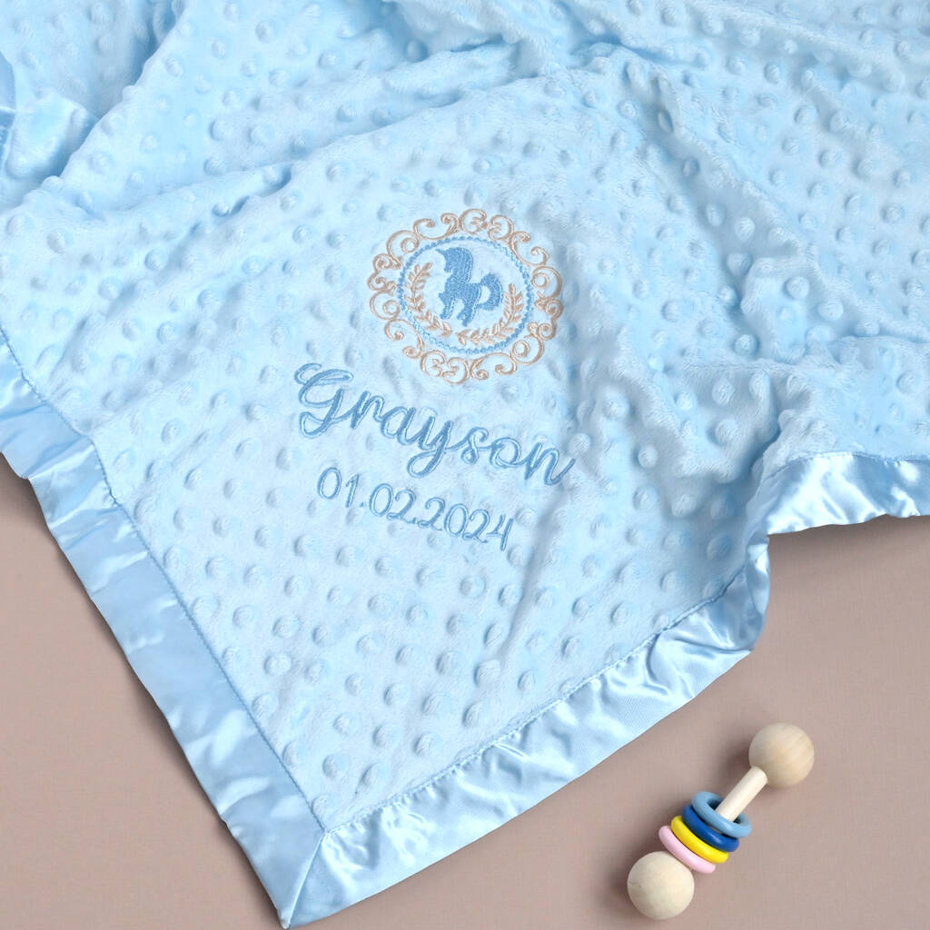 A personalised baby blue bauble blanket with embroidered rocking horse and the name 'Grayson'.