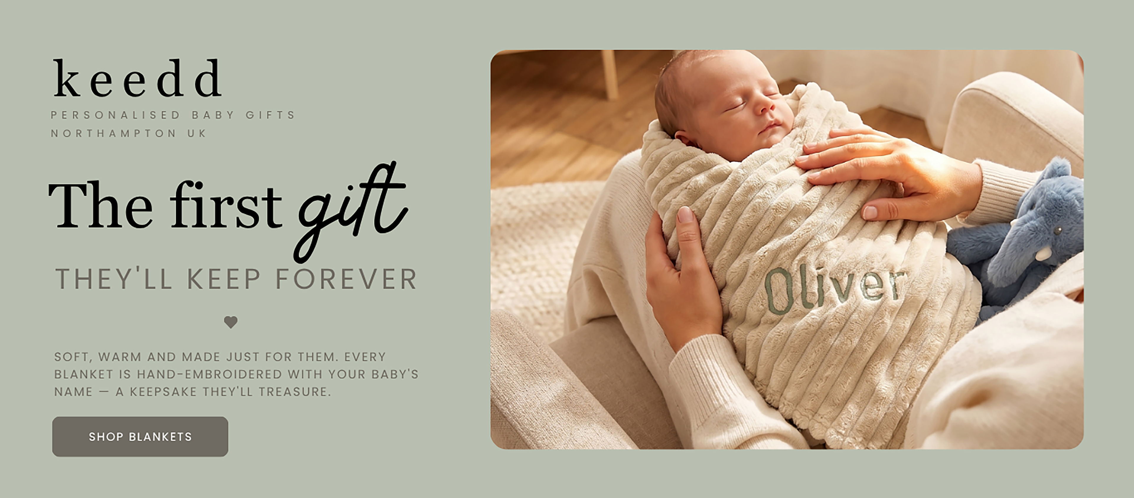 Newborn baby wrapped in a blanket with 'Oliver' embroidered, held by an adult's hands, on a light background.