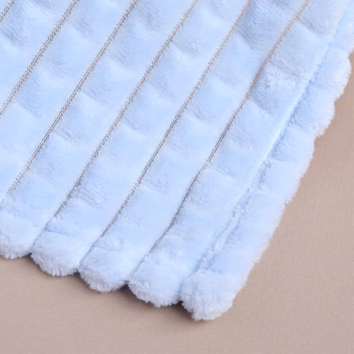 Blue ribbed fleece baby blanket folded flat, showing the diagonal ribbed texture across the fabric.