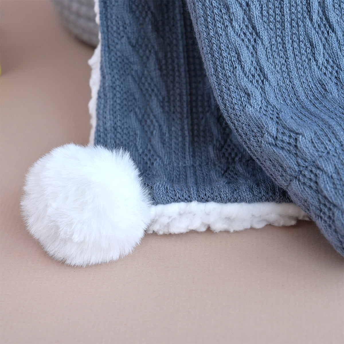 knitted baby blanket with pom poms