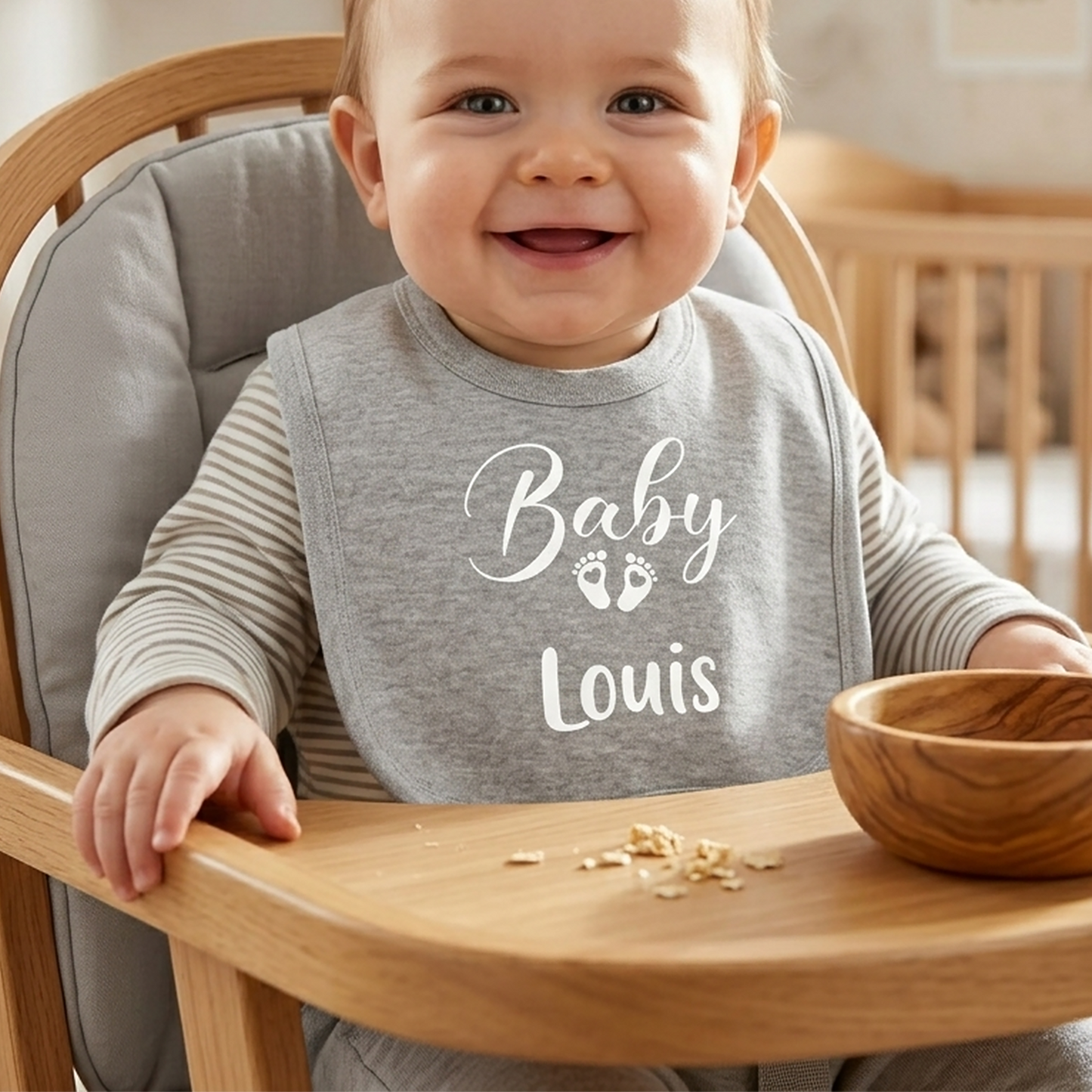 Grey personalised "Baby" bib with footprint icons and name "Louis" printed in white