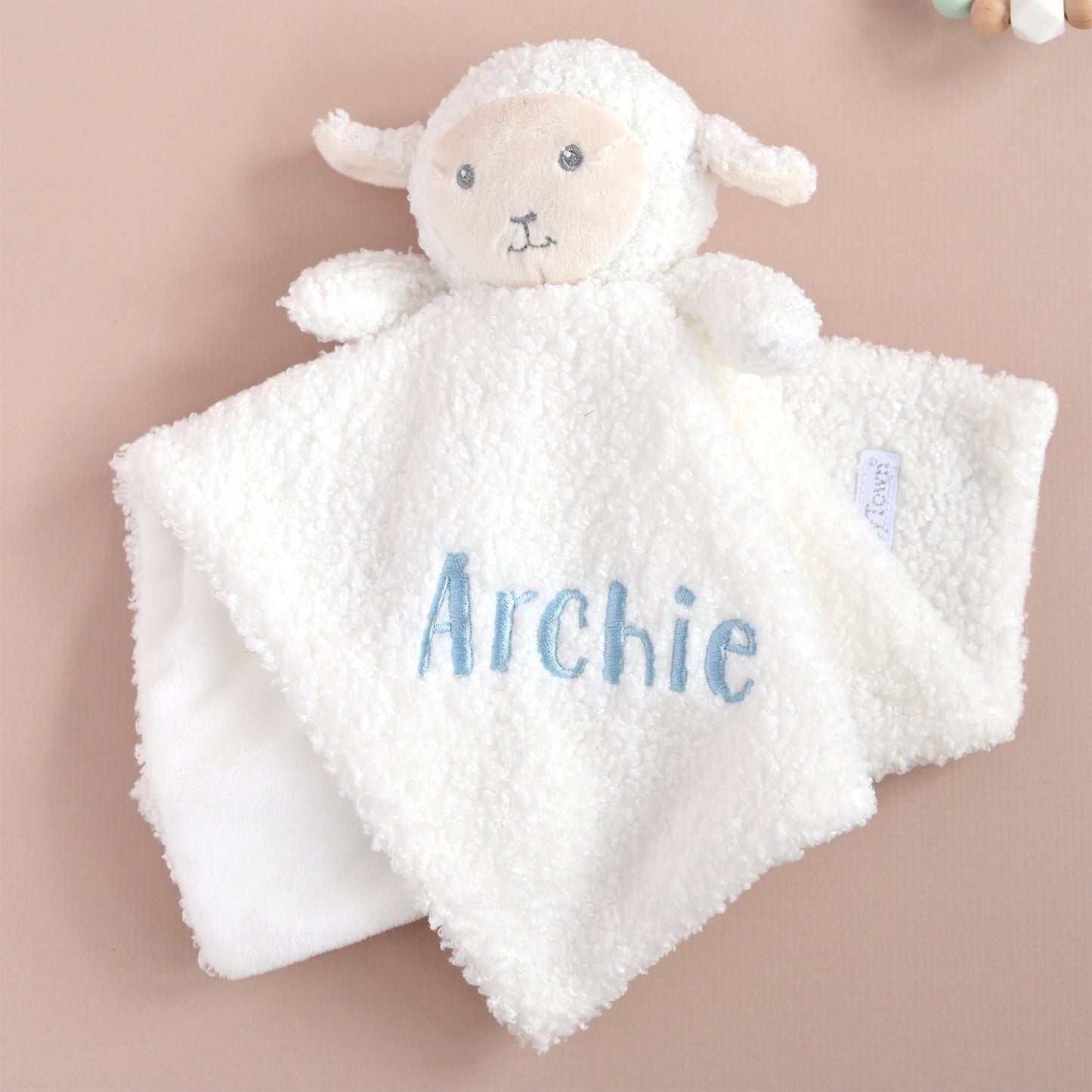 A white plush sheep baby security blanket with a soft fleece panel, personalized with the name 'Archie' in light blue embroidery. The sheep has a cream-colored face and small embroidered facial features.