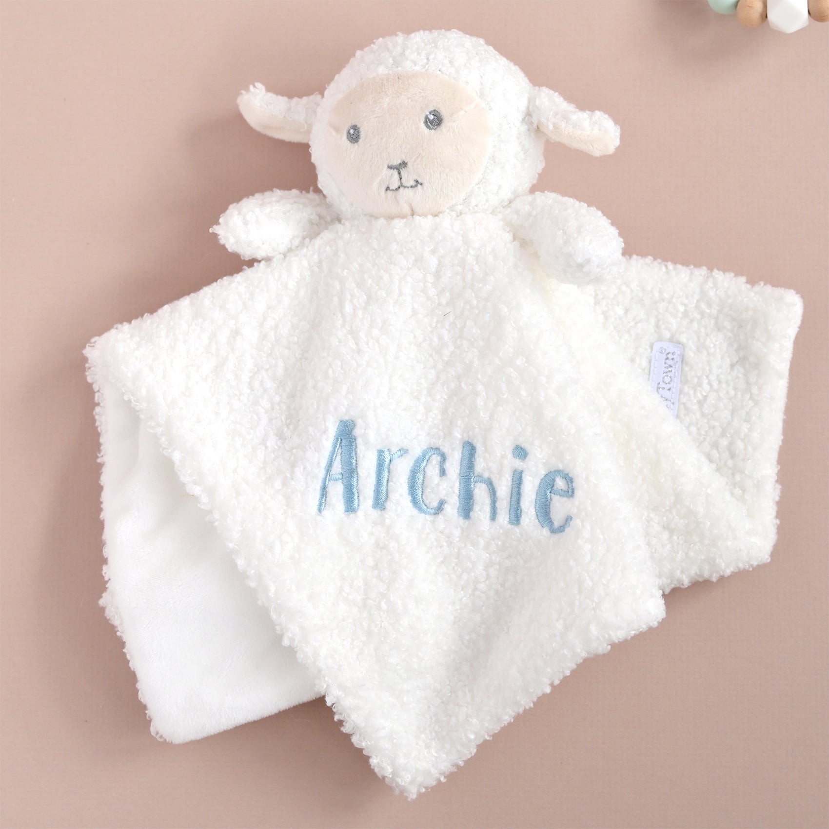 A white plush sheep baby security blanket with a soft fleece panel, personalized with the name 'Archie' in light blue embroidery. The sheep has a cream-colored face and small embroidered facial features.