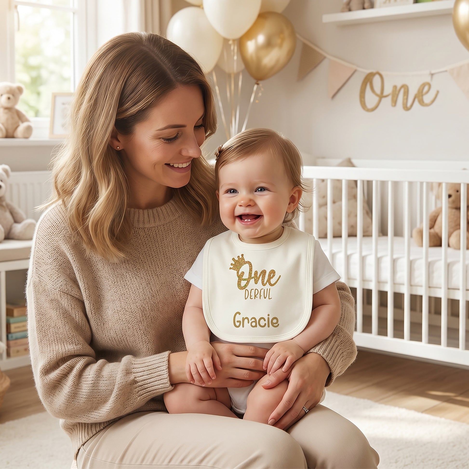 Ivory personalised 1st birthday baby bib with gold glitter crown, "One-derful" wording and name "Gracie" printed in gold