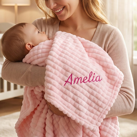 Woman cradling a baby wrapped in a pink ribbed fleece blanket personalised with the name Amelia.