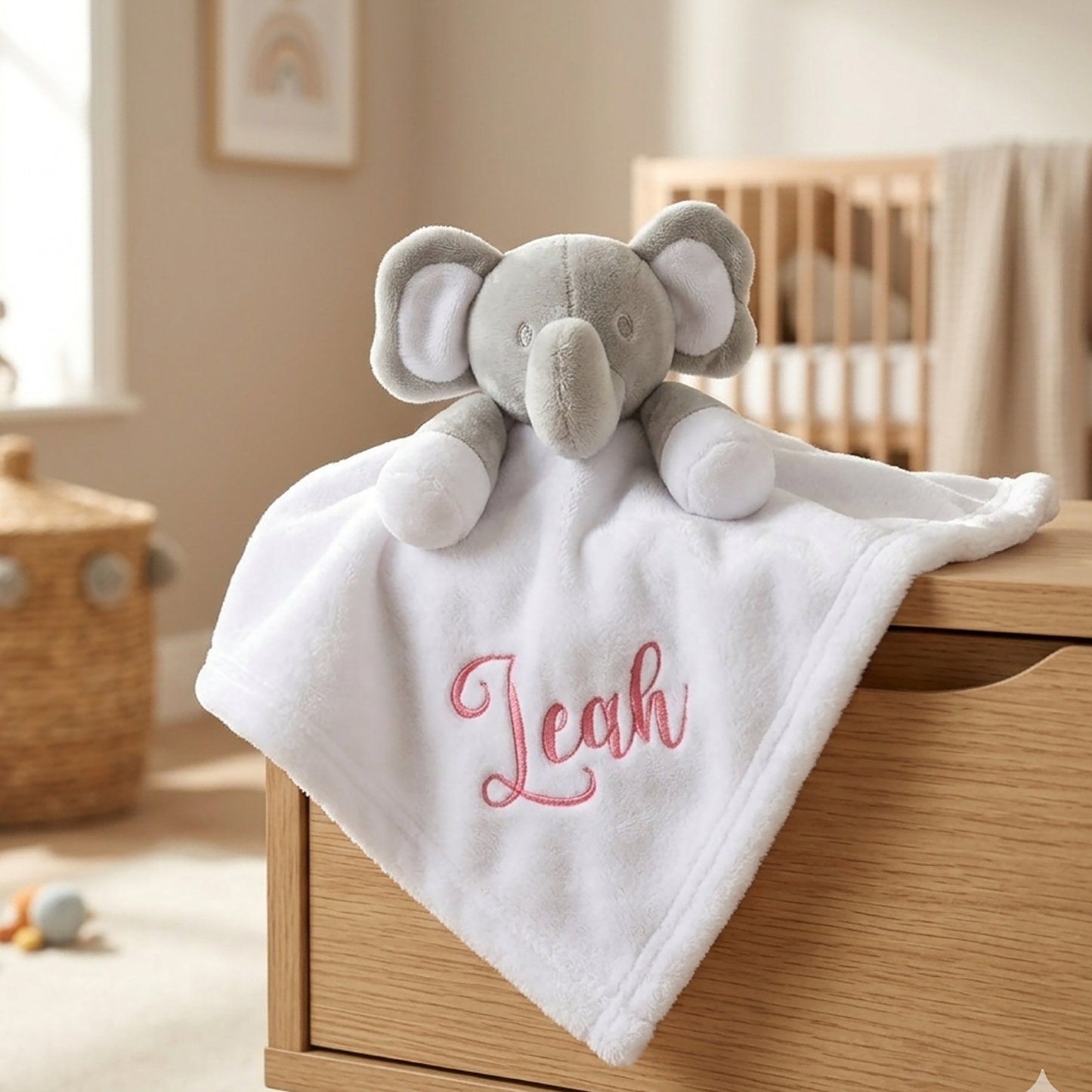 white elephant comforter, personalised with the name "Leah" in pink script embroidery.