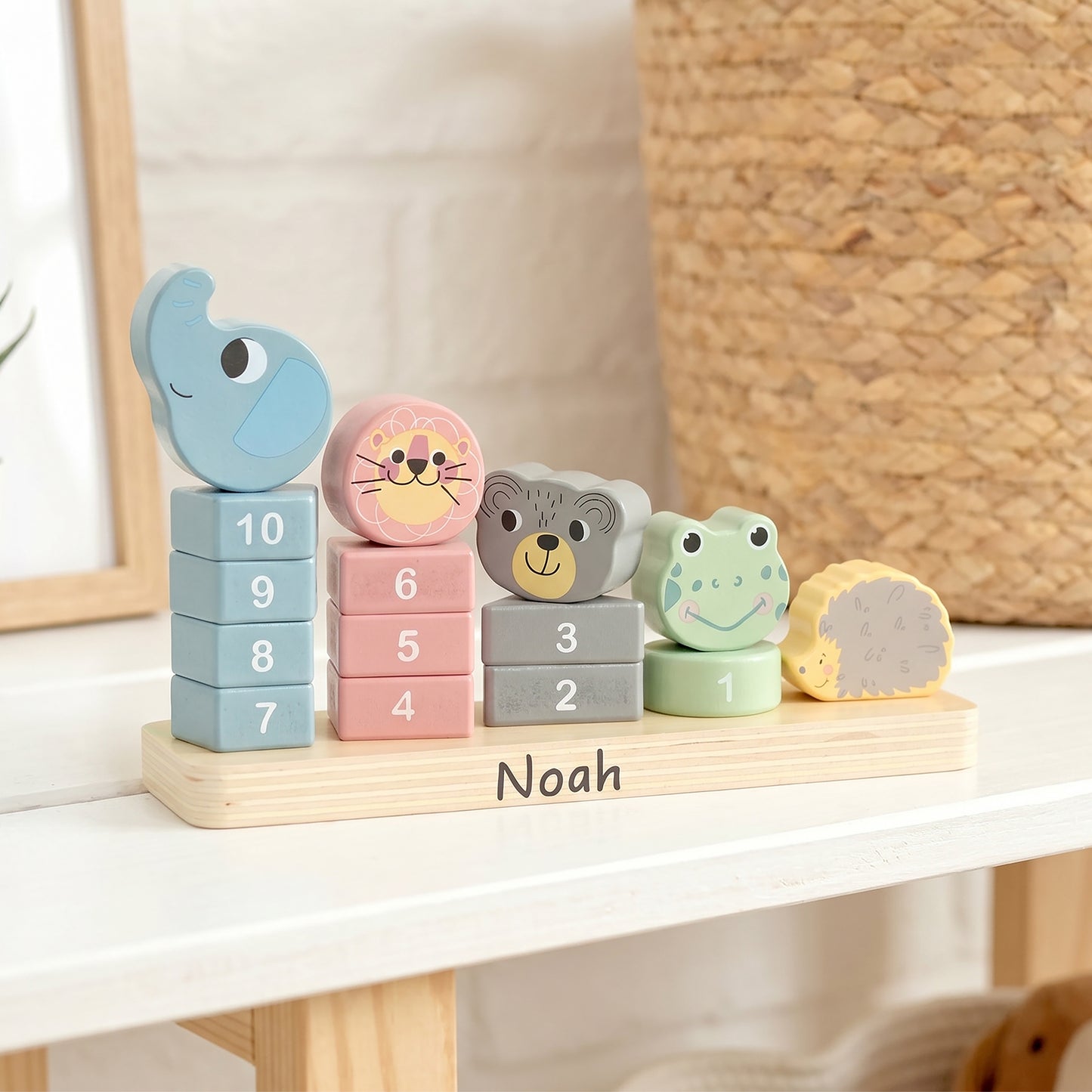 Personalized wooden number blocks and animal faces arranged on a light wood base labeled 'Noah', displayed on a white shelf in a nursery-like setting.